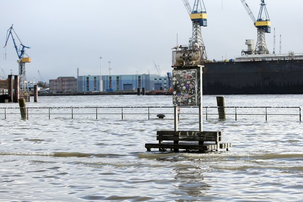 Eine Sitzbank am Hamburger Hafen wird von der Flut überspült.