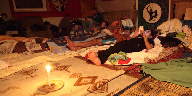 Flüchtlinge liegen auf Decken im Pfadfinderheim