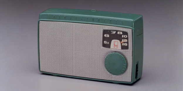 Das Bild zeigt ein altes Transistorradio, das auf einem Tisch steht.