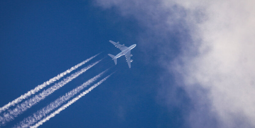 Flzgzeug und Kondensstreifen am blauen Himmel