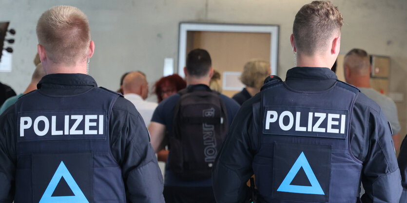 Polizisten vor einem Verhandlungssaal