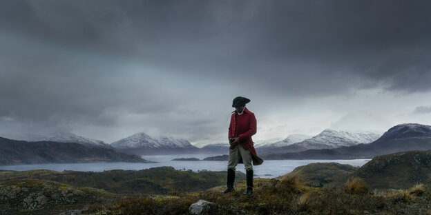Ein schwarzer Mann in kolonialer Uniform steht in einer Landschaft wie von Caspar David Friedrich