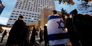Menschen mit Israelfahne versammeln sich vor einem Hotel