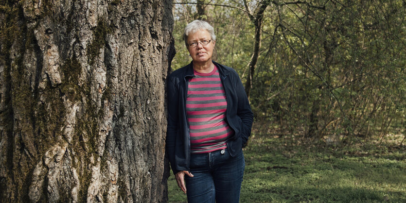 Eine Frau steht an einem Baum gelehnt