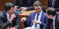 Hendrik Wüst spricht mit Marcus Opendrenk und Nathanael Liminski im Düsseldorfer Landtag