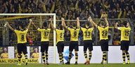 Dortmunder Spieler im schwarz-gelben Trikot heben gemeinsam die Arme hoch - vor der Zuschauertribüne