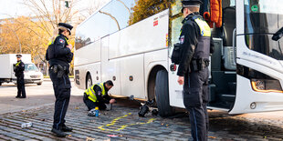 Einsatzkräfte stehen nach einem Unfall mit einem Radfahrer und einem Reisebus am Unfallort.