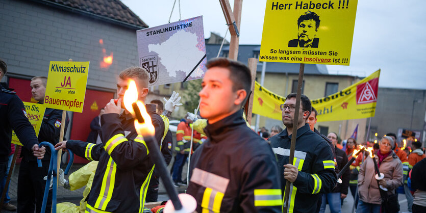 Protestierende Stahlarbeiter mit Fackeln und Protestschildern.