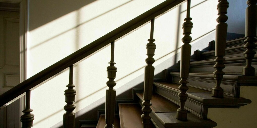 Die Sonne scheint auf eine Treppe im Altbau