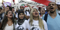 Junge Protestierende vor einer Fahne des Libanon.