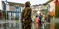 Ein Mann und eine Frau in Bundeswehruniformen vor dem Kanzleramt in Berlin