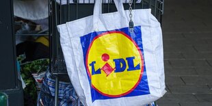 Eine Lidl-Tüte hängt an einem Einkaufswagen