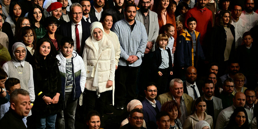 Thüringens Innenminister Georg Maier (SPD) steht beim Einbürgerungsfest des Freistaates Thüringen im Erfurter Kaisersaal mit eingebürgerten Menschen für ein Gruppenfoto beisammen