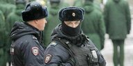 zwei russische Polizisten in Dienstkleidung, einer schaut in die Kamera