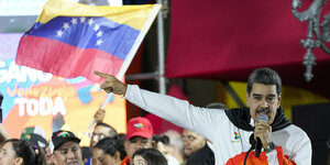 Madura vor einer Fahne Venezuelas mit Mikrofon