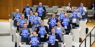 Fraktionsmitglieder der AfD halten Schilder mit Aufschrift „Keine Heizung ist illegal“ während der Debatte im niedersächsischen Landtag.