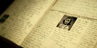 Handschriftlich beschriebene Seiten in holländisch mit einem kleinen Foto von Anne Frank