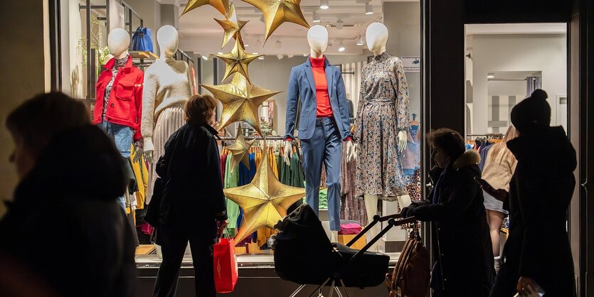 Personen laufen an einem Schaufenster vorbei