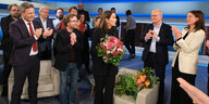 Applaudierende Talkshowgäste und Anne Will mit Blumen