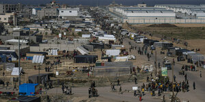 Viele Menschen auf den Straßen neben einem UN Zeltlager