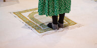 Füße von einer Frau ohne Schuhe auf einem Gebetsteppich