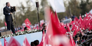 Erdoğan bei einer Wahlveranstaltung mit vielen Fahnen um ihn herum