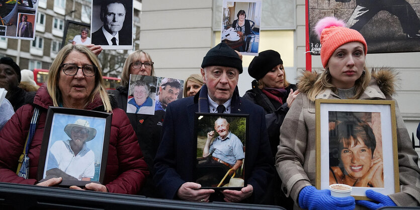 Menschen protestieren mit Fotos ihrer Angehörigen, die während der Corona-Krise verstorben sind.