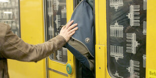 Eine Person drückt eine andere Person in eine Überfüllte U-Bahn.