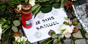 Blumen, Kerzen und ein Blatt mit der Aufschrift „Je suis Samuel“