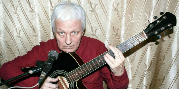 Älterer Mann spielt Gitarre in seinem Heimstudio