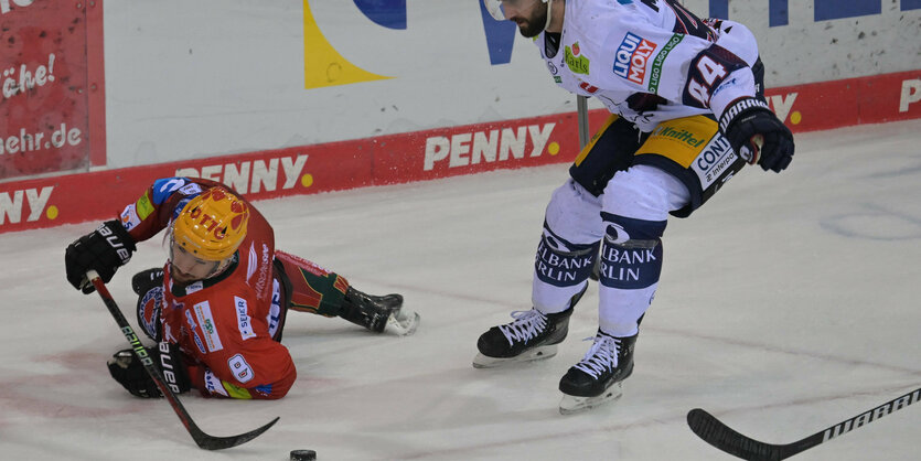 ein Eishockeyspieler im roten Trikot liegt am Boden