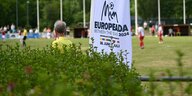ein Banner der Europeada 2024 steht am Rande eines Fubßballplatzes