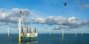 Ein Helikopter fliegt über den Offshore-Windpark Riffgat in der Nordsee.