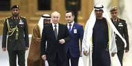 Putin und Sheikh Mohamed bin Zayed Al Nahyan laufen nebeneinander her, gefogt von vier weiteren Männern.