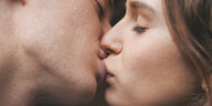 Ein junges Paar küsst sich auf den Mund