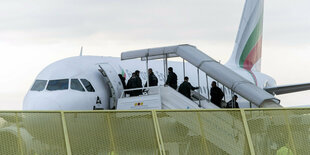 Menschen steigen in ein Flugzeug