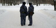 Zwei Polizisten auf einer schneebedeckten Straße