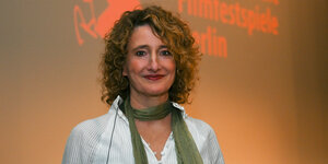 Tricia Tuttle vor einem Logo der Internationalen Filmfestspiele Berlin