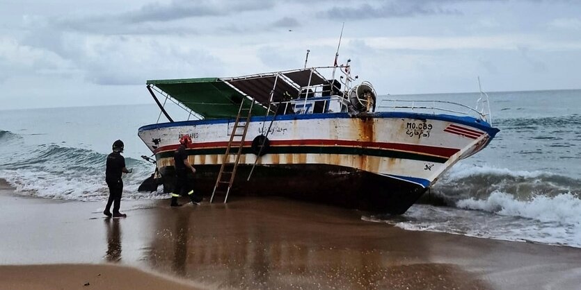 Ein kleines Schiff liegt an einem Strand