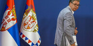 Aleksandar Vučić geht an zwei serbischen Fahnen vorbei
