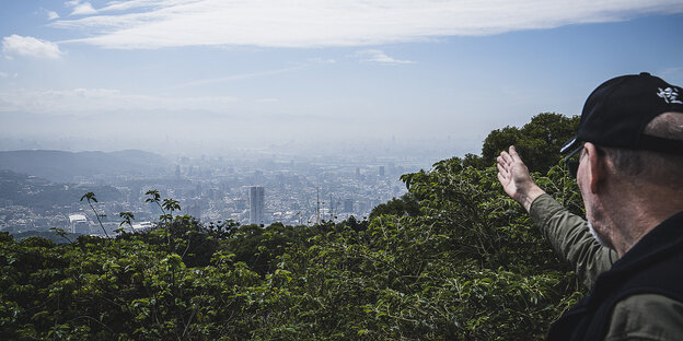 Taipeh von einem Berg aus gesehen, am rechten Bildrand steht Tobie Openshwa und deutet auf die Stadt