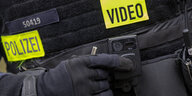 Ein Polizist schaltet die Bodycam auf seiner Uniform ein, aufgenommen bei einem Pressetermin zur Ausweitung des Einsatzes von Bodycams bei Berliner Polizei und Feuerwehr.