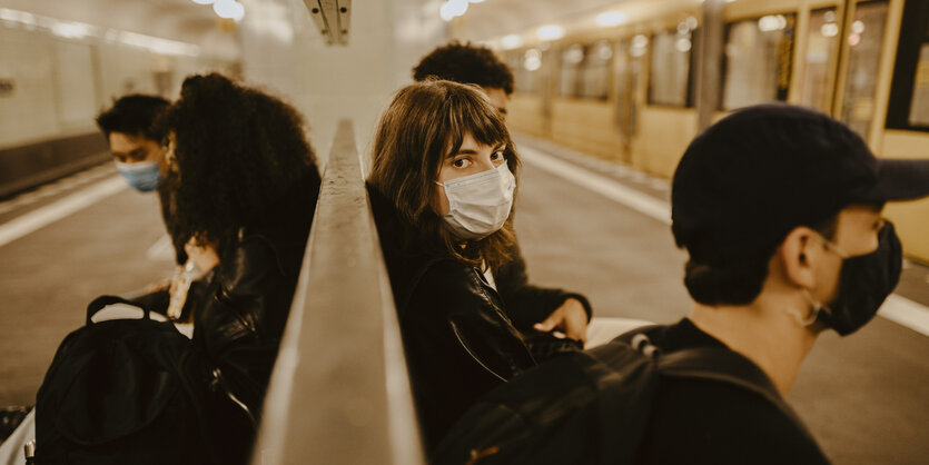 Fahrgäste mit Maske warten auf eine U-Bahn in Berlin