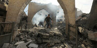 Nach einem Luftangriff läuft ein Mann über die Trümmer
