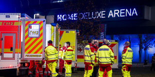 Rettungswagen und Sanitäter vor einem Fußballstadion