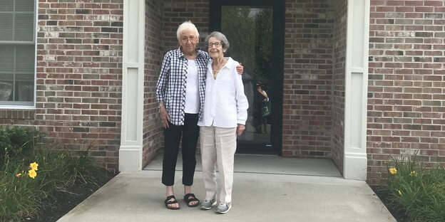 Zwei alte Frauen stehen vor einer Haustür