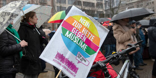 Eine Frau hält ein Plakat mit der Aufschrift "Nein zur hetze gegen Muslime" am Start der Demonstration "Gemeinsam gegen Rassismus und Faschismus".