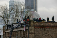 Besetzer*innen und Polizist*innen stehen auf dem Dach der Dondorf-Druckrei in Frankfurt