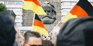 Menschen die Deutschlandfahnen schwenken vor dem Karl-Marx-Kopf in Chemnitz
