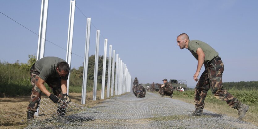 Ungarische Soldaten beim Bau des Grenzzauns zwischen Ungarn und Kroatien in der Nähe des Ortes Beremend..